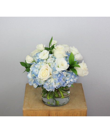 The Coastal Waves arrangement is a serene blend of blue and white flowers that evoke the calming essence of the ocean.