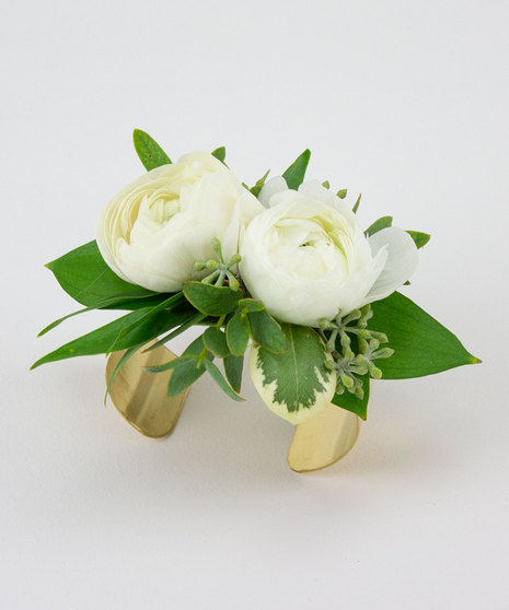 A traditional corsage featuring two ranunculus vase.