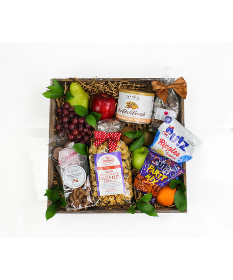 Assorted seasonal fruit and local snacks including Popsations popcorn, Mouth party caramels, McAllen's Toffee, and Wockenfuss Peanut butter cups!